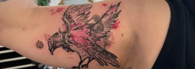 Black and grey crow tattoo with pink accents by Rian