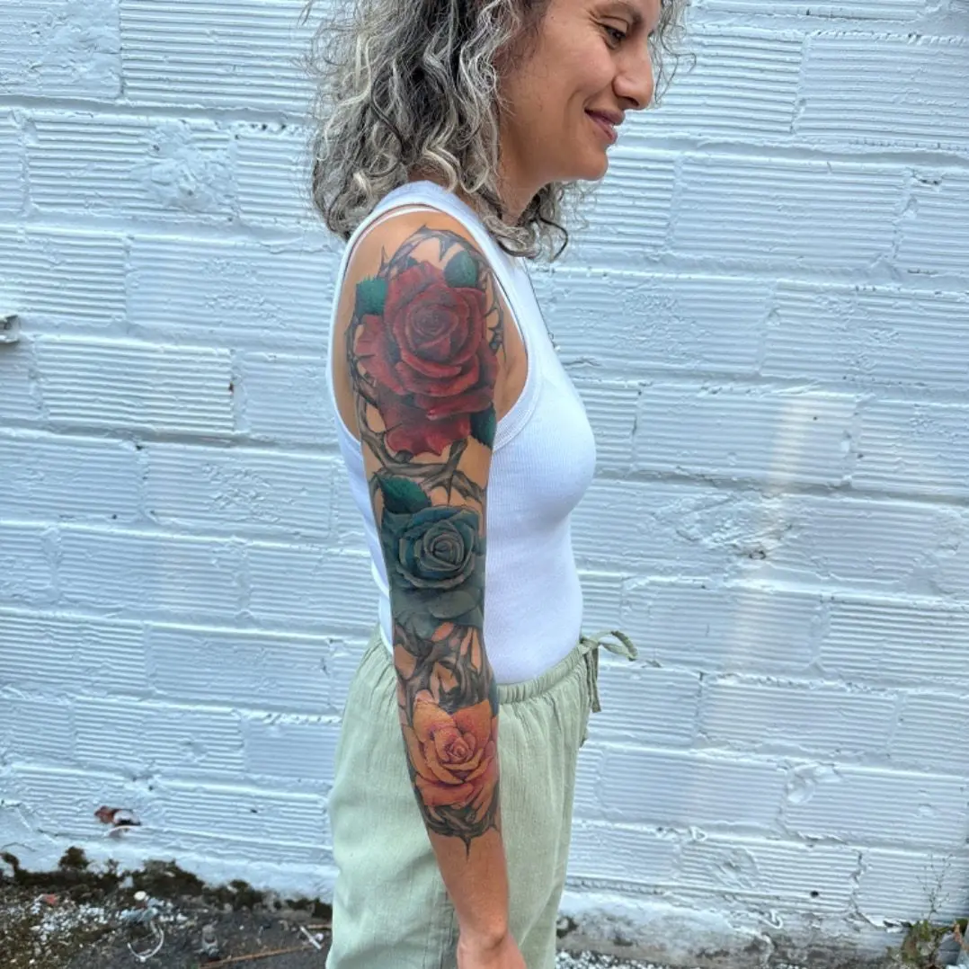 rework tattoo of roses on an arm. Full sleeve