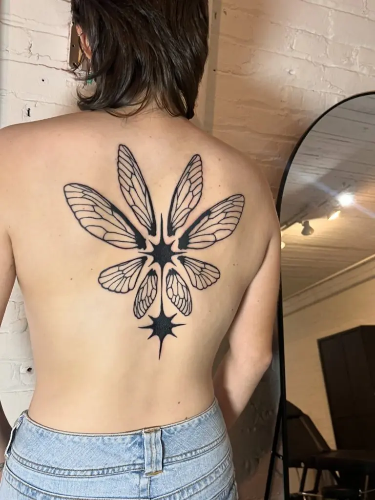 Solid black ornamental flower tattoo on the upper back by Fae