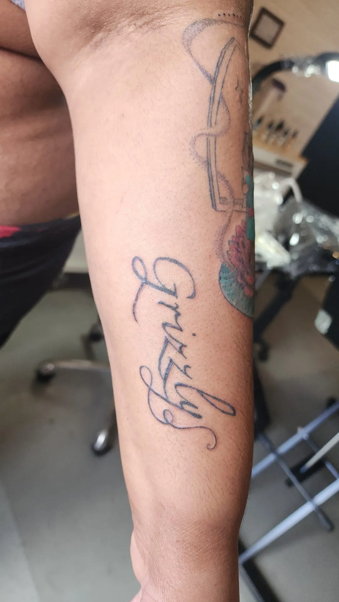 Script lettering reading Grizzly on a forearm